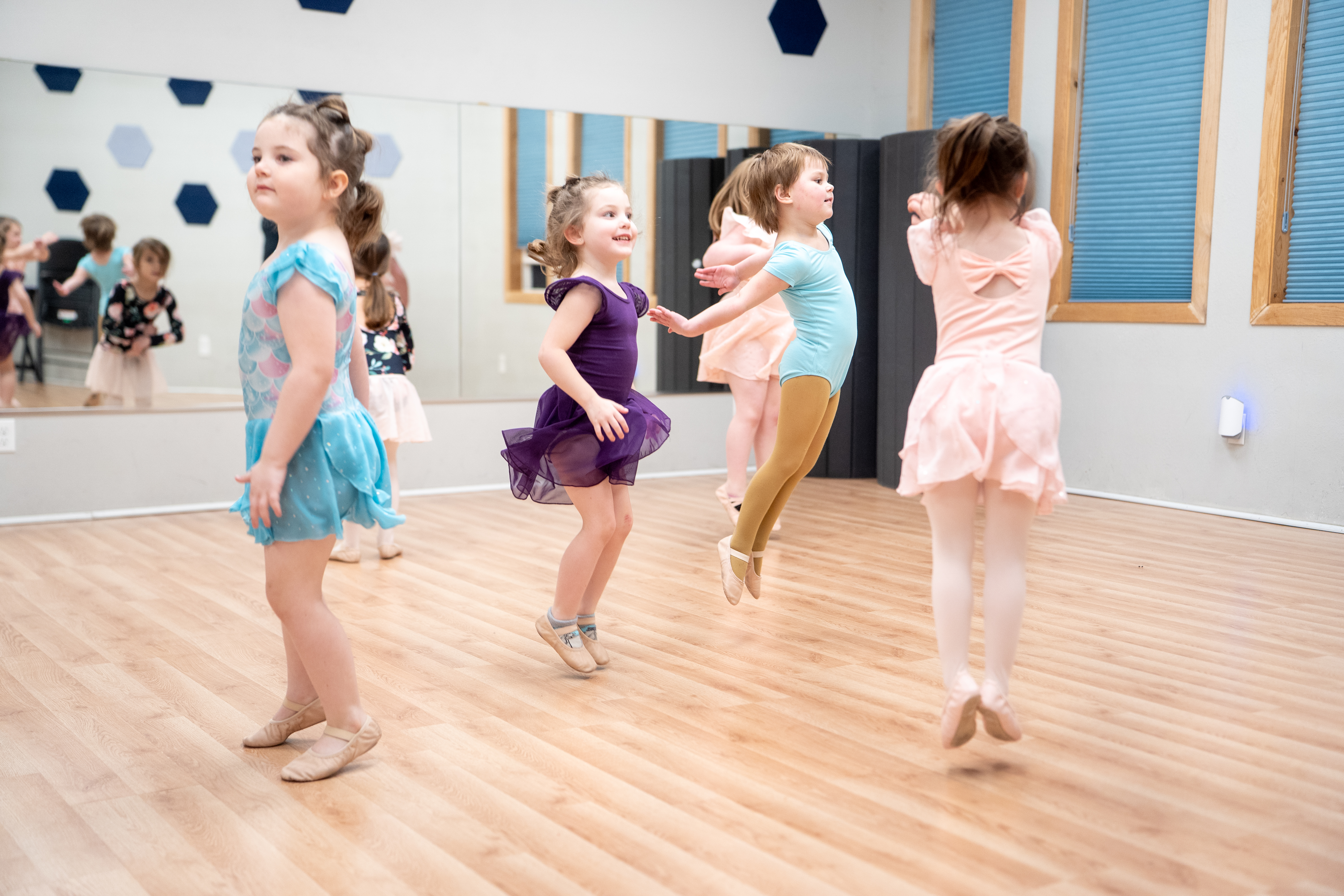Young Inspirations Academy dancers jumping during class in colorful dancewear