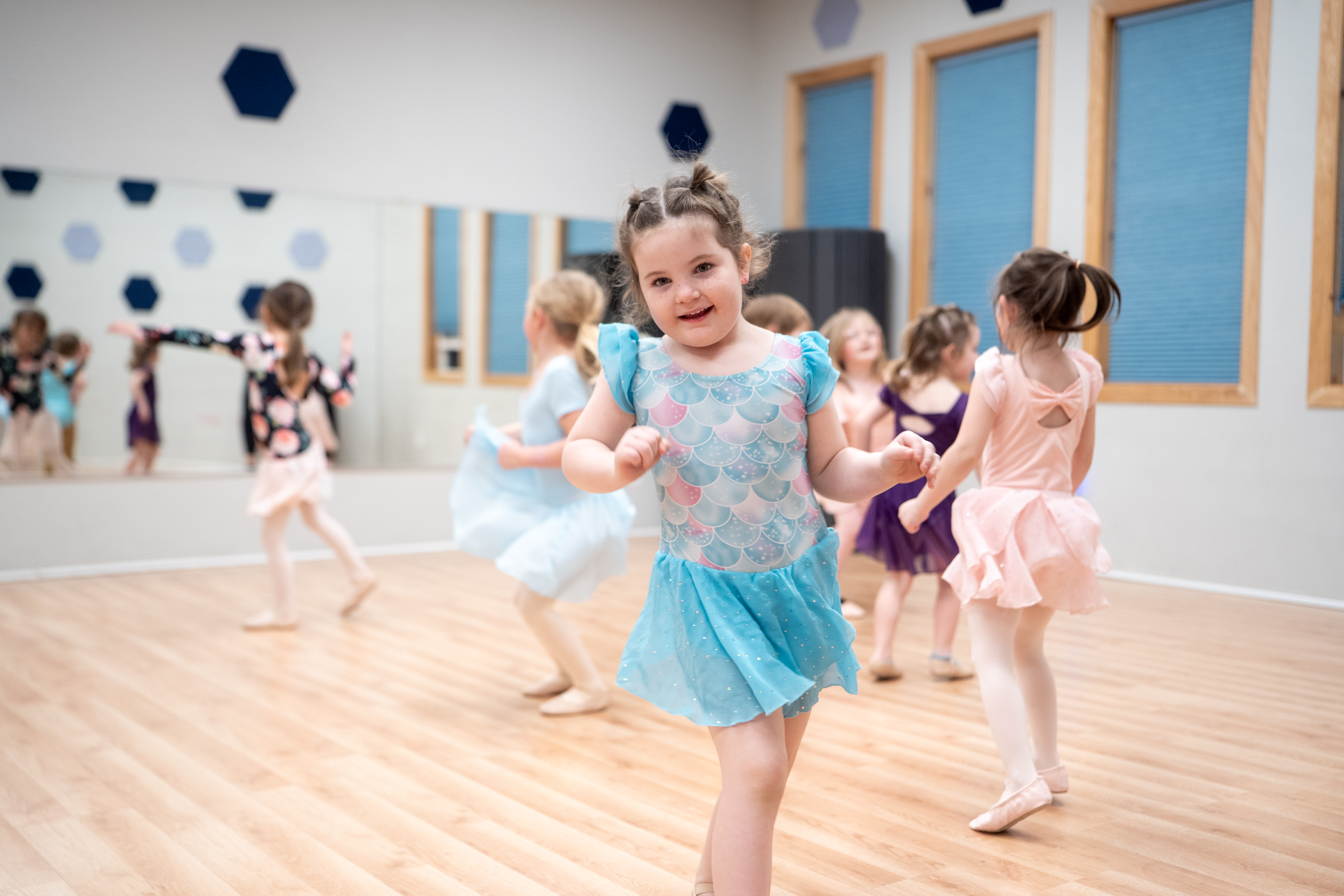 Young dancers in a preschool dance class at Inspirations Academy, with mirrors and hexagon wall decals